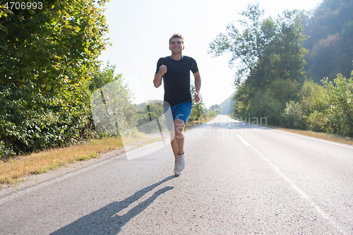 Image of man jogging along a country road