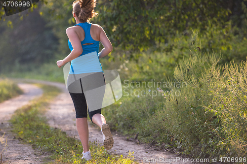 Image of woman jogging along a country road