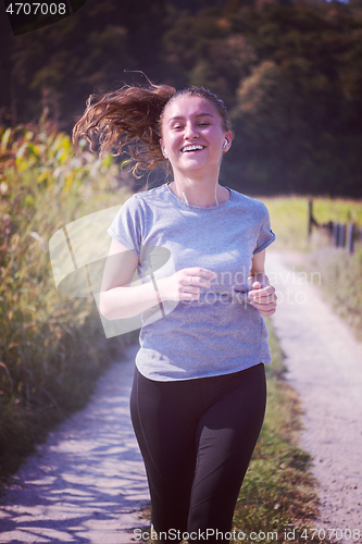 Image of woman jogging along a country road