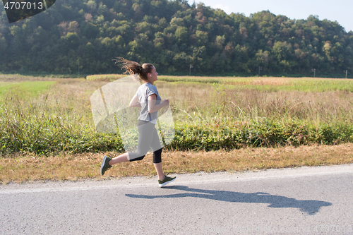 Image of woman jogging along a country road