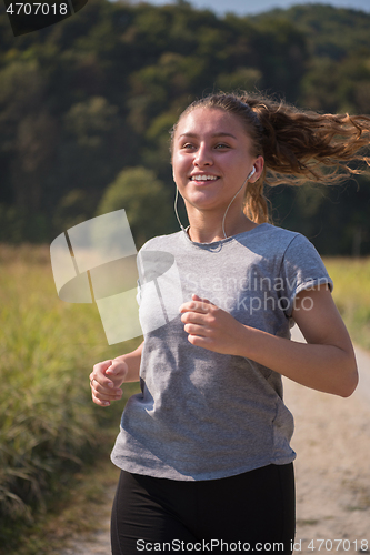 Image of woman jogging along a country road