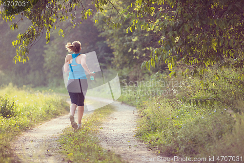 Image of woman jogging along a country road