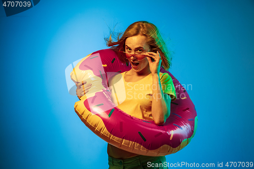 Image of Beautiful woman in neon light isolated on blue studio background