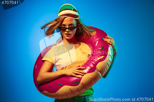 Image of Beautiful woman in neon light isolated on blue studio background