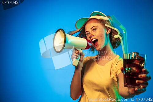 Image of Beautiful woman in neon light isolated on blue studio background