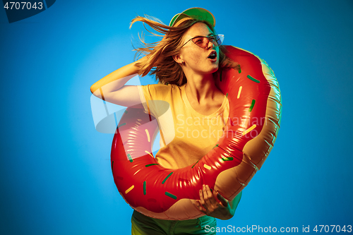 Image of Beautiful woman in neon light isolated on blue studio background