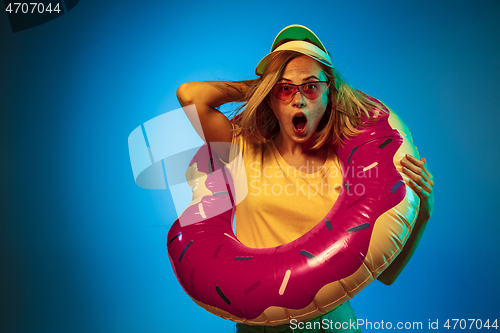 Image of Beautiful woman in neon light isolated on blue studio background