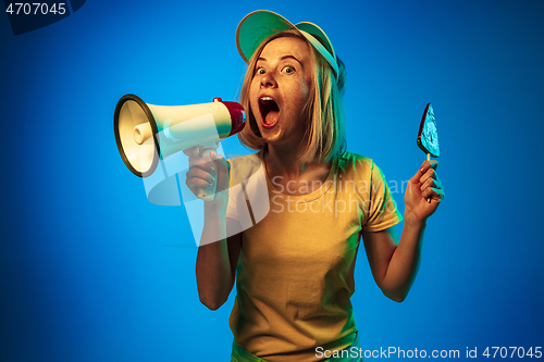 Image of Beautiful woman in neon light isolated on blue studio background