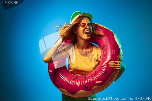 Image of Beautiful woman in neon light isolated on blue studio background