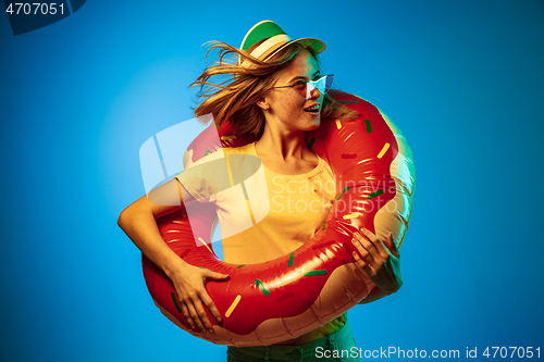 Image of Beautiful woman in neon light isolated on blue studio background