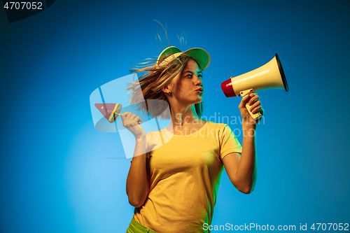 Image of Beautiful woman in neon light isolated on blue studio background