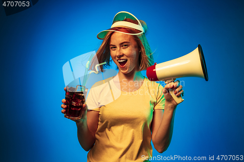 Image of Beautiful woman in neon light isolated on blue studio background