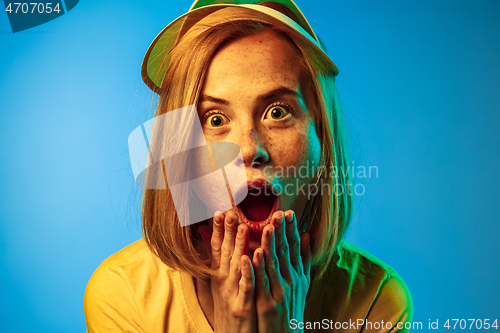 Image of Beautiful woman in neon light isolated on blue studio background