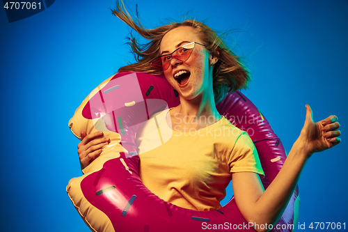 Image of Beautiful woman in neon light isolated on blue studio background