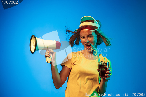 Image of Beautiful woman in neon light isolated on blue studio background