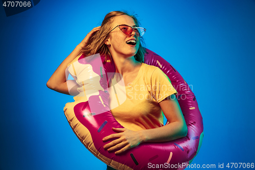 Image of Beautiful woman in neon light isolated on blue studio background