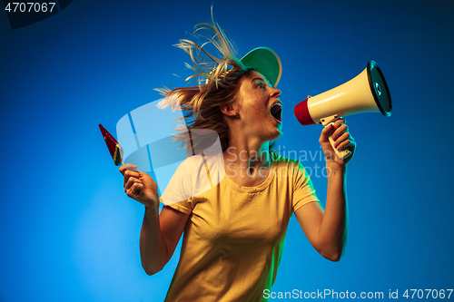 Image of Beautiful woman in neon light isolated on blue studio background