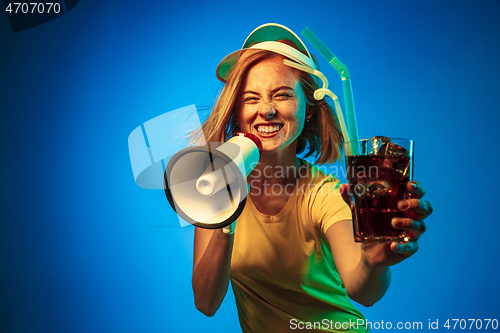 Image of Beautiful woman in neon light isolated on blue studio background