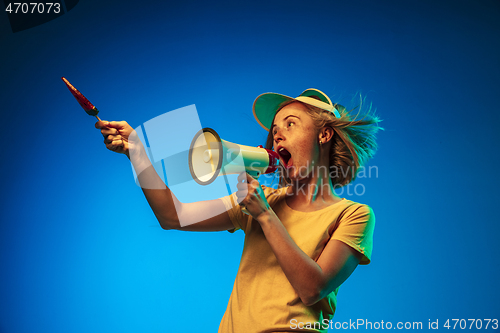 Image of Beautiful woman in neon light isolated on blue studio background