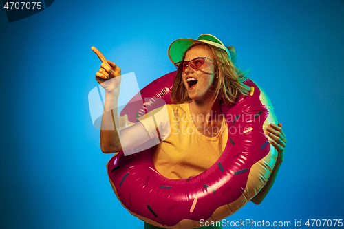 Image of Beautiful woman in neon light isolated on blue studio background