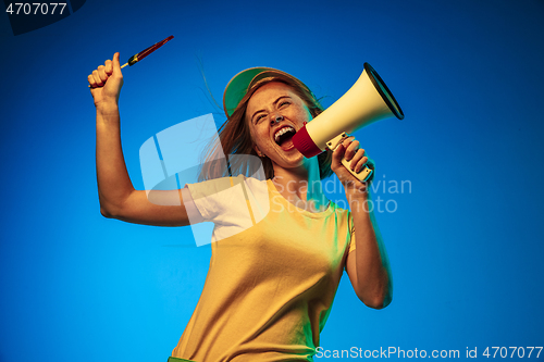 Image of Beautiful woman in neon light isolated on blue studio background