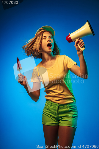 Image of Beautiful woman in neon light isolated on blue studio background