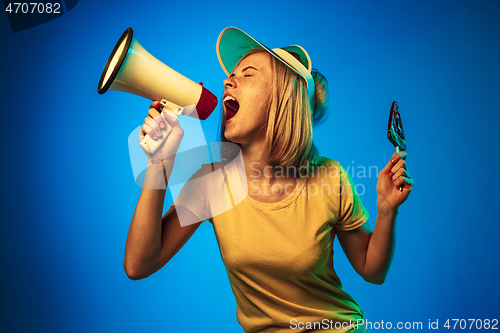 Image of Beautiful woman in neon light isolated on blue studio background