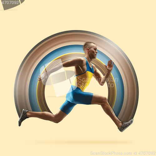 Image of Young caucasian man running or jogging isolated on yellow studio background.