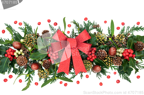 Image of Winter Greenery with Holly and Red Glitter Bow 