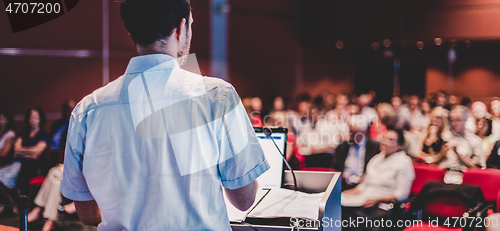 Image of Public speaker giving talk at Business Event.