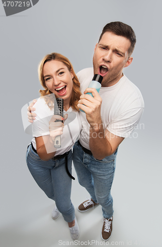 Image of happy couple singing to hairbrush and lotion