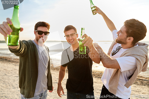 Image of young men toasting non alcoholic beer on beach