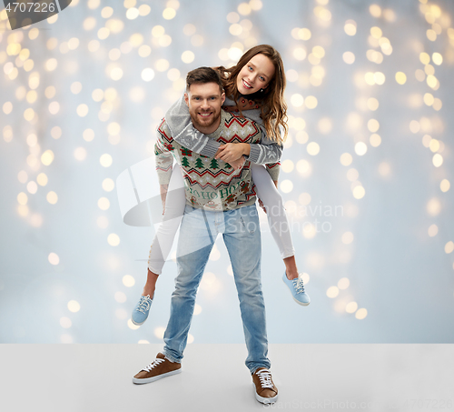 Image of happy couple at christmas ugly sweater party