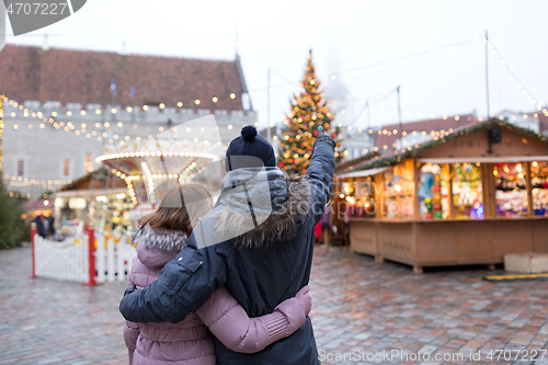 Image of happy senior couple hugging at christmas market