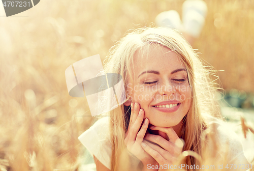 Image of happy woman or teen girl lying in cereal field