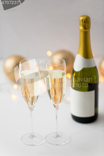 Image of two glasses of champagne and bottle on christmas