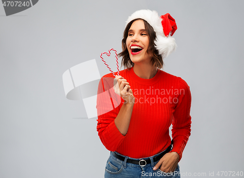 Image of happy young woman in santa hat on christmas