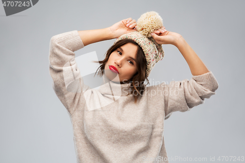 Image of young woman in knitted winter hat and sweater