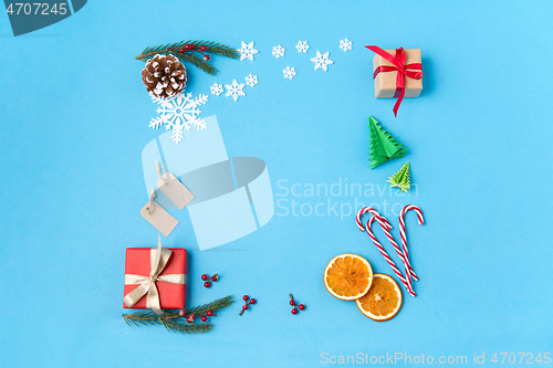 Image of frame of gifts, fir branches, tags and decorations