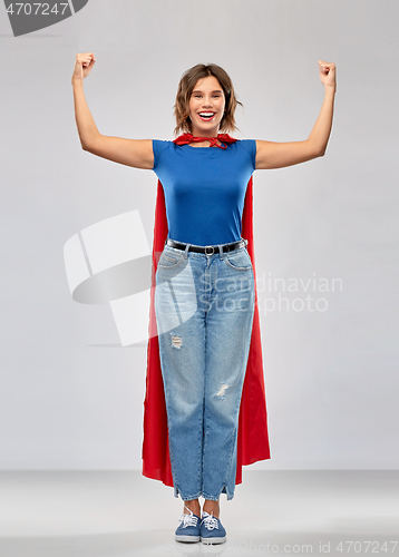 Image of happy woman in red superhero cape showing power