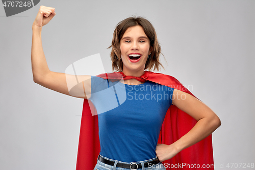 Image of happy woman in red superhero cape showing power