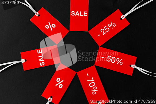 Image of red tags with discount signs on black background