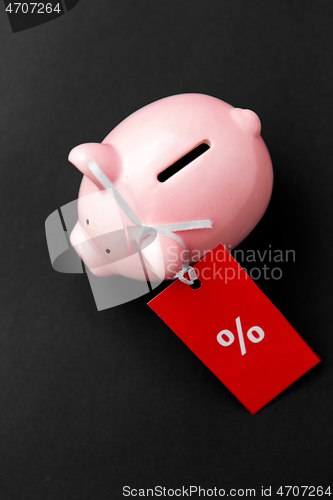 Image of piggy bank with red sale tag on black