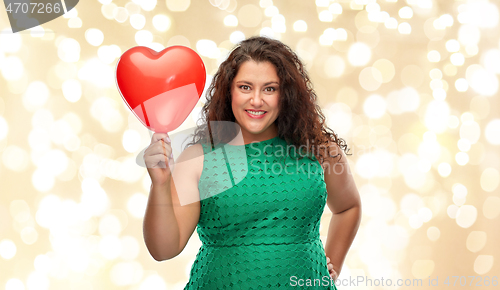 Image of happy woman holding red heart shaped balloon