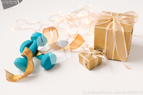 Image of christmas gift boxes and dumbbells on white