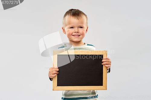 Image of portrait of smiling boy holding black chalk board