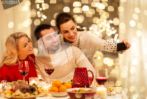 Image of friends taking selfie at christmas dinner