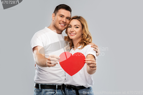 Image of smiling couple holding big red heart