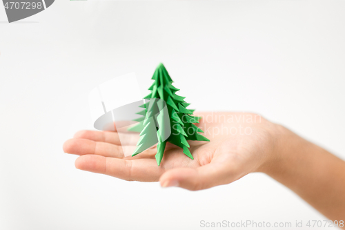 Image of hand holding green paper origami christmas tree