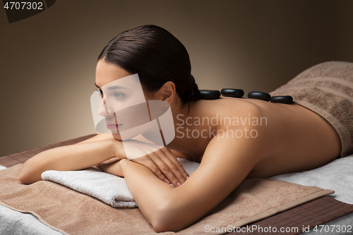 Image of woman having hot stone massage at spa